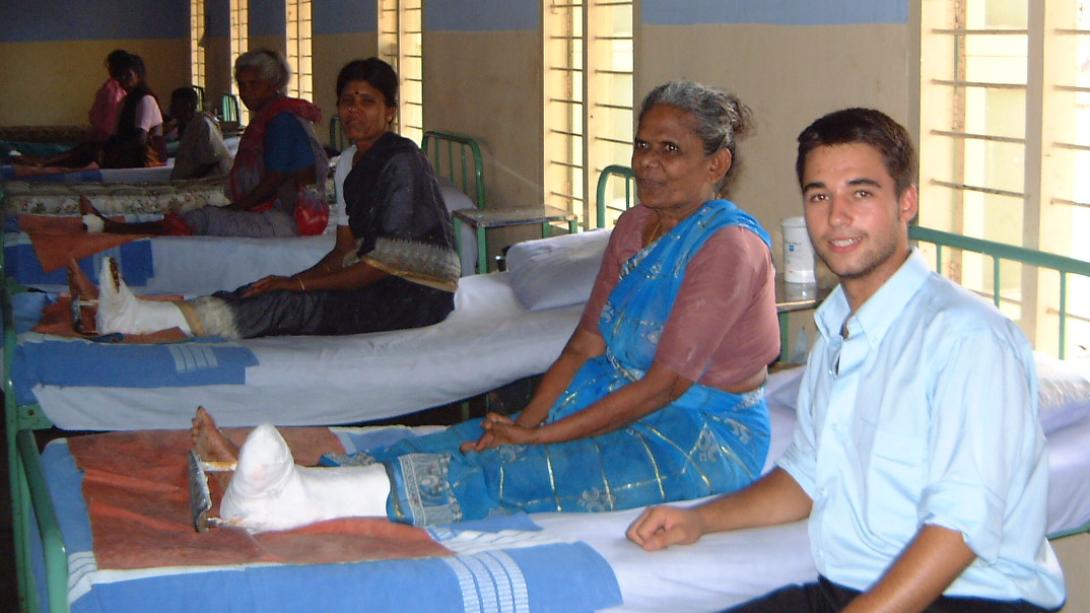 Projects Abroad intern comforts a patient in the hospital in India. Medical intern sitting next to a local woman who received medical attention on her foot in India.